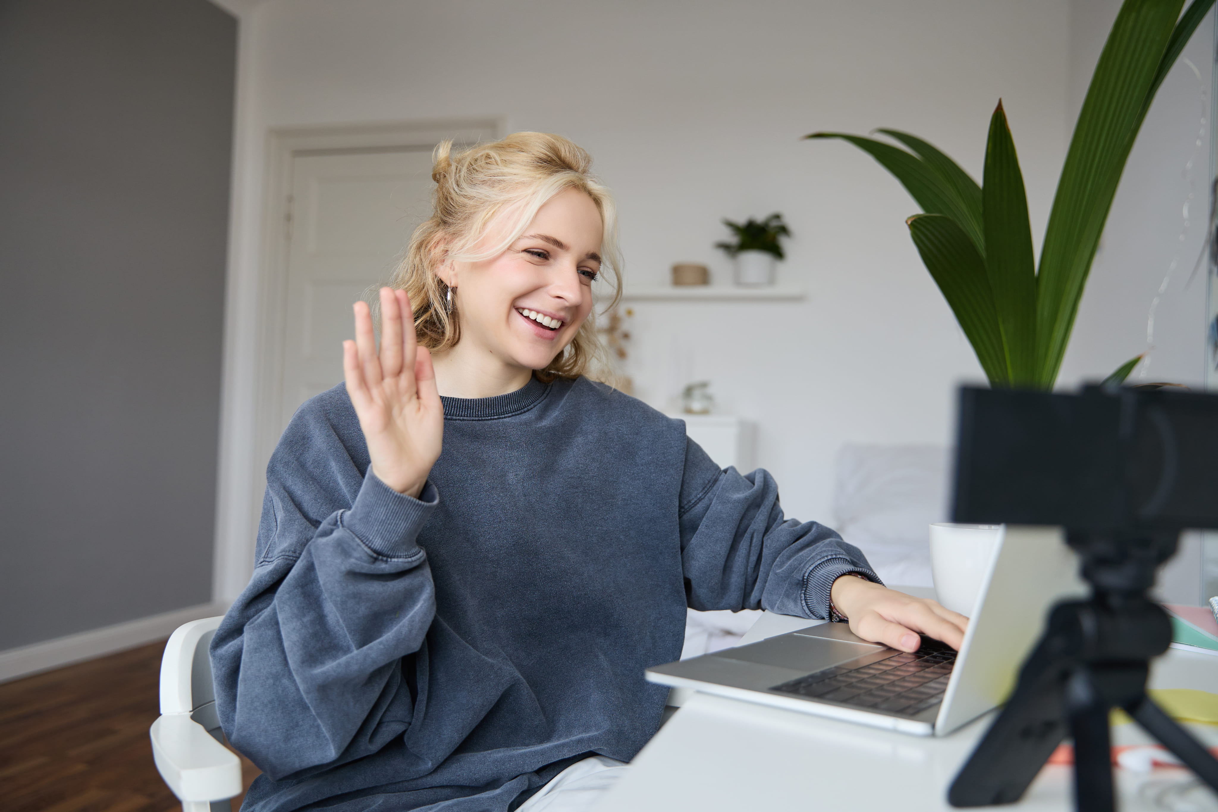 Une femmes qui sourit devant un ordinateur